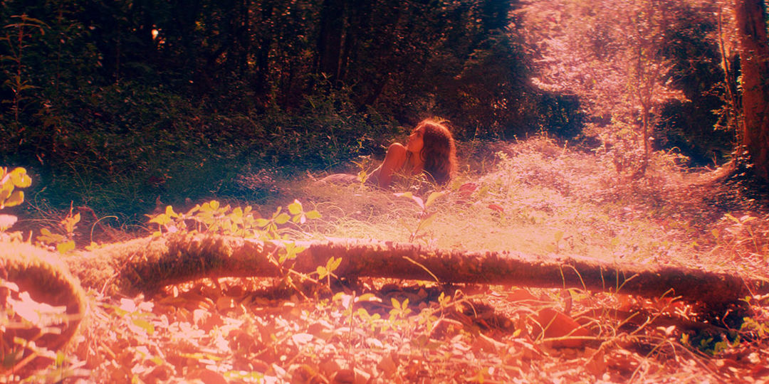 IMAGE: Still - Tamara in red light lying in grass